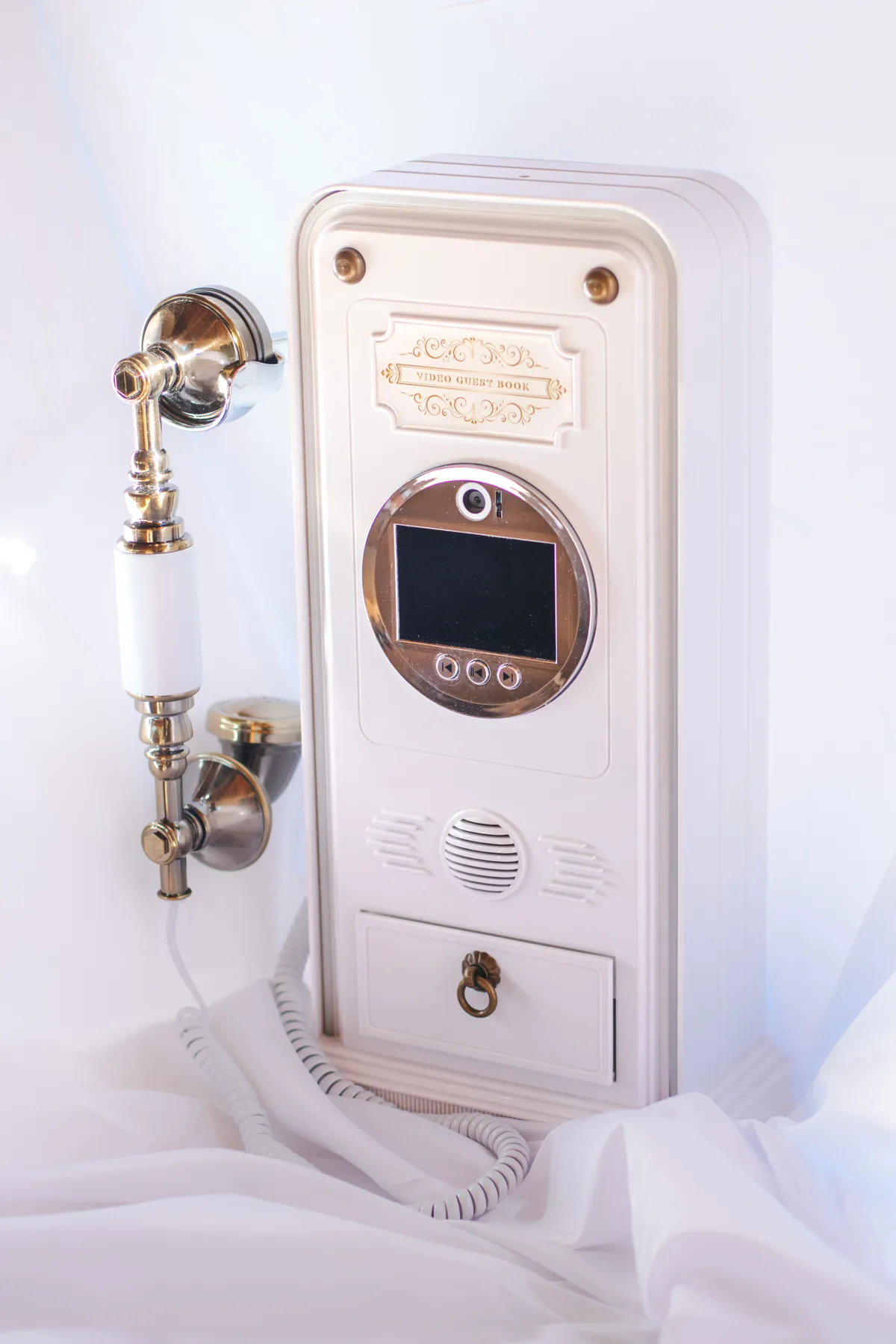 Le livre d'or audio : un téléphone rétro blanc et doré, avec son combiné, pour laisser un message vocal.