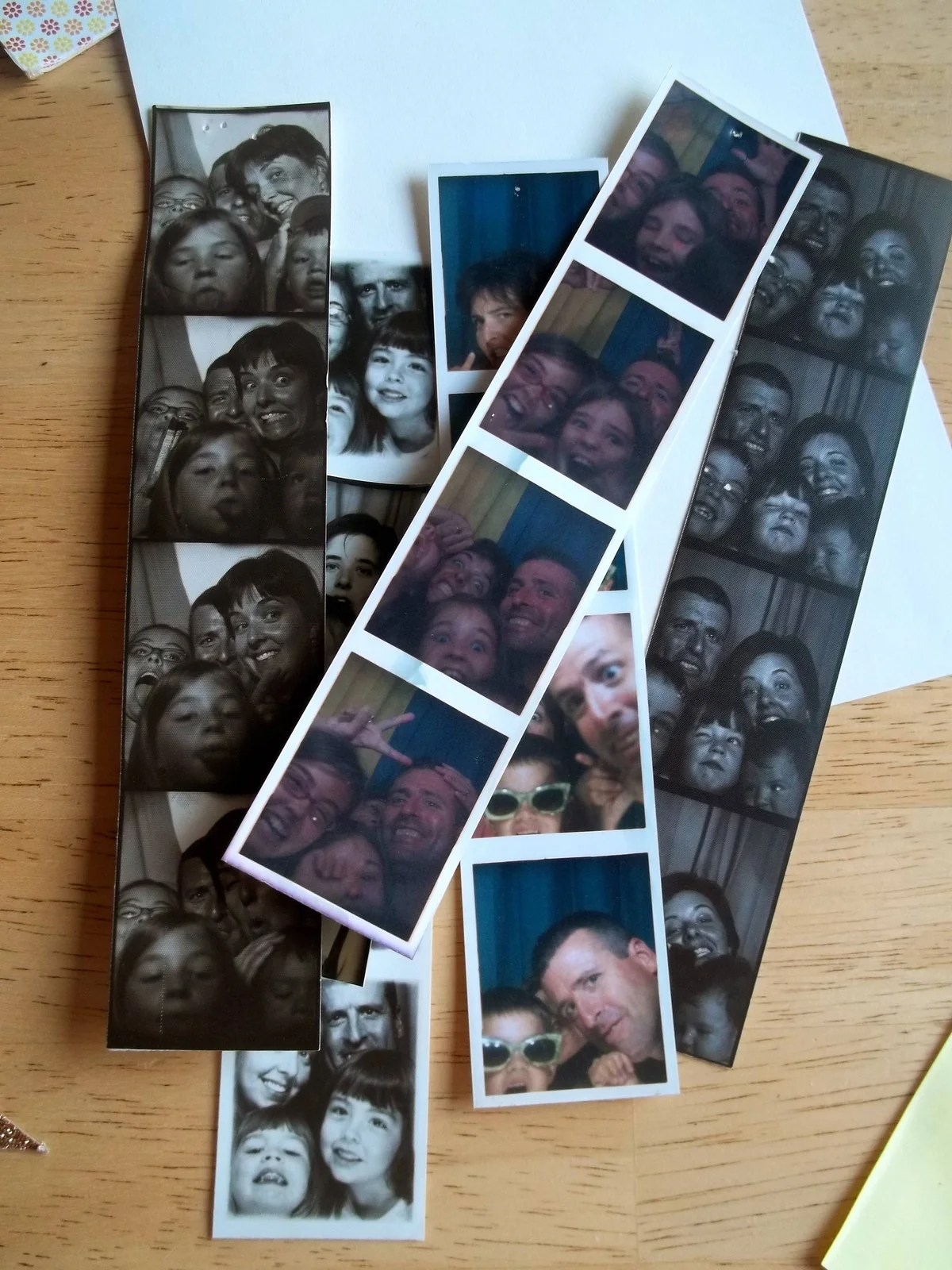 De nombreux tirages photo disposés sur une table en bois.